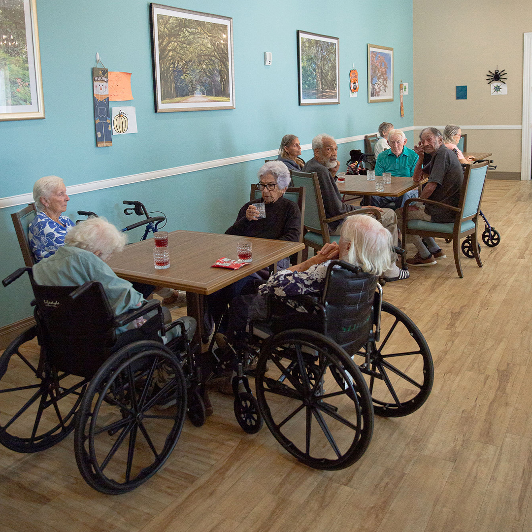 Residents socializing in a common area with wheelchairs