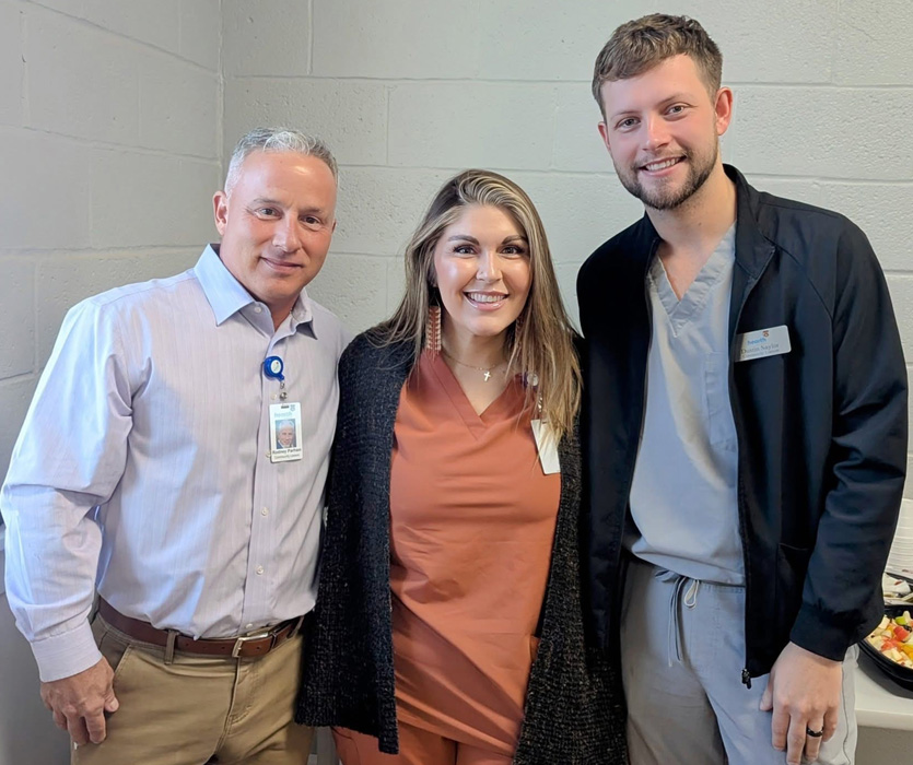 Three staff members smiling together