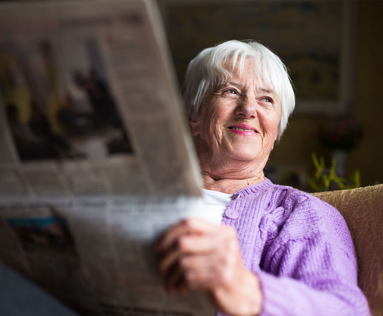 Senior woman reading a newspaper indoors