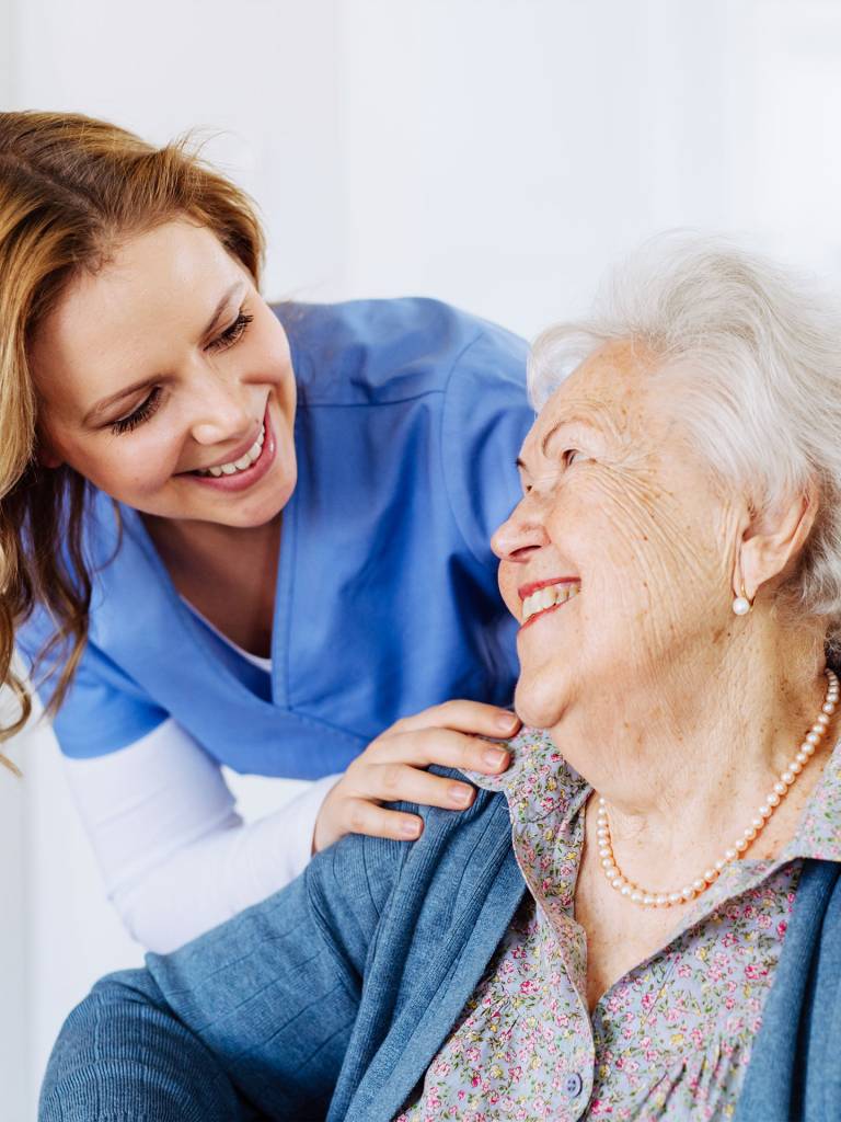 Caregiver smiling with elderly resident