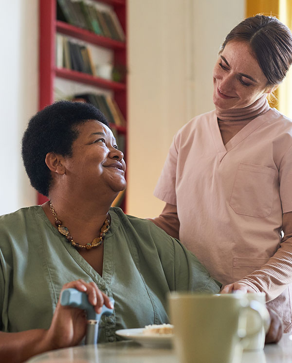 A caregiver interacting with a resident in a cozy setting.