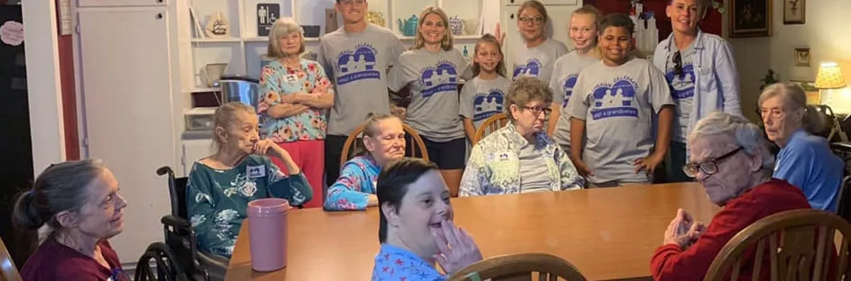 Group of residents and staff in a common area.