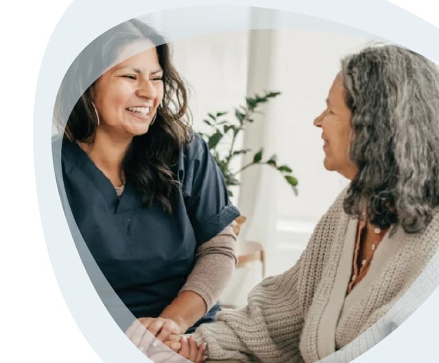 Caregiver and resident sharing a joyful moment indoors.