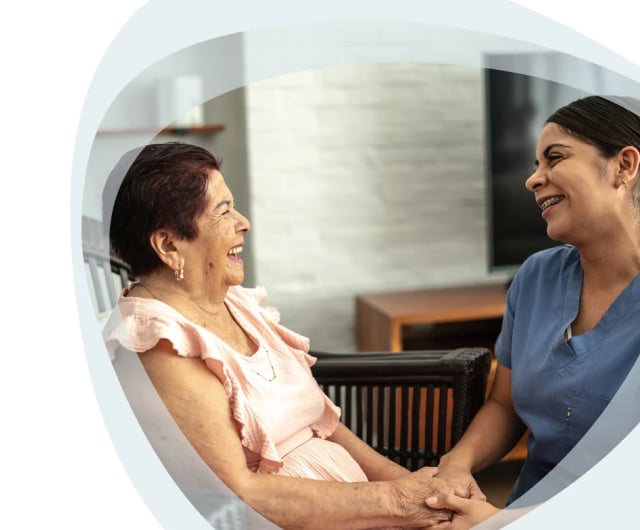 Smiling nurse interacting with elderly resident