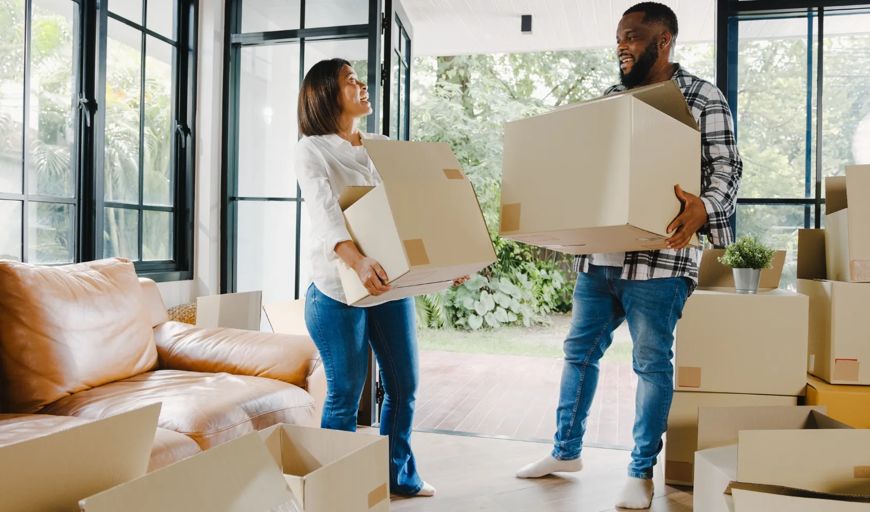 Couple moving boxes into a living space