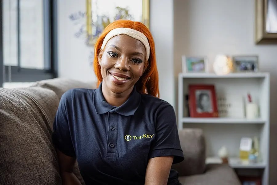 Staff member smiling in a cozy interior.