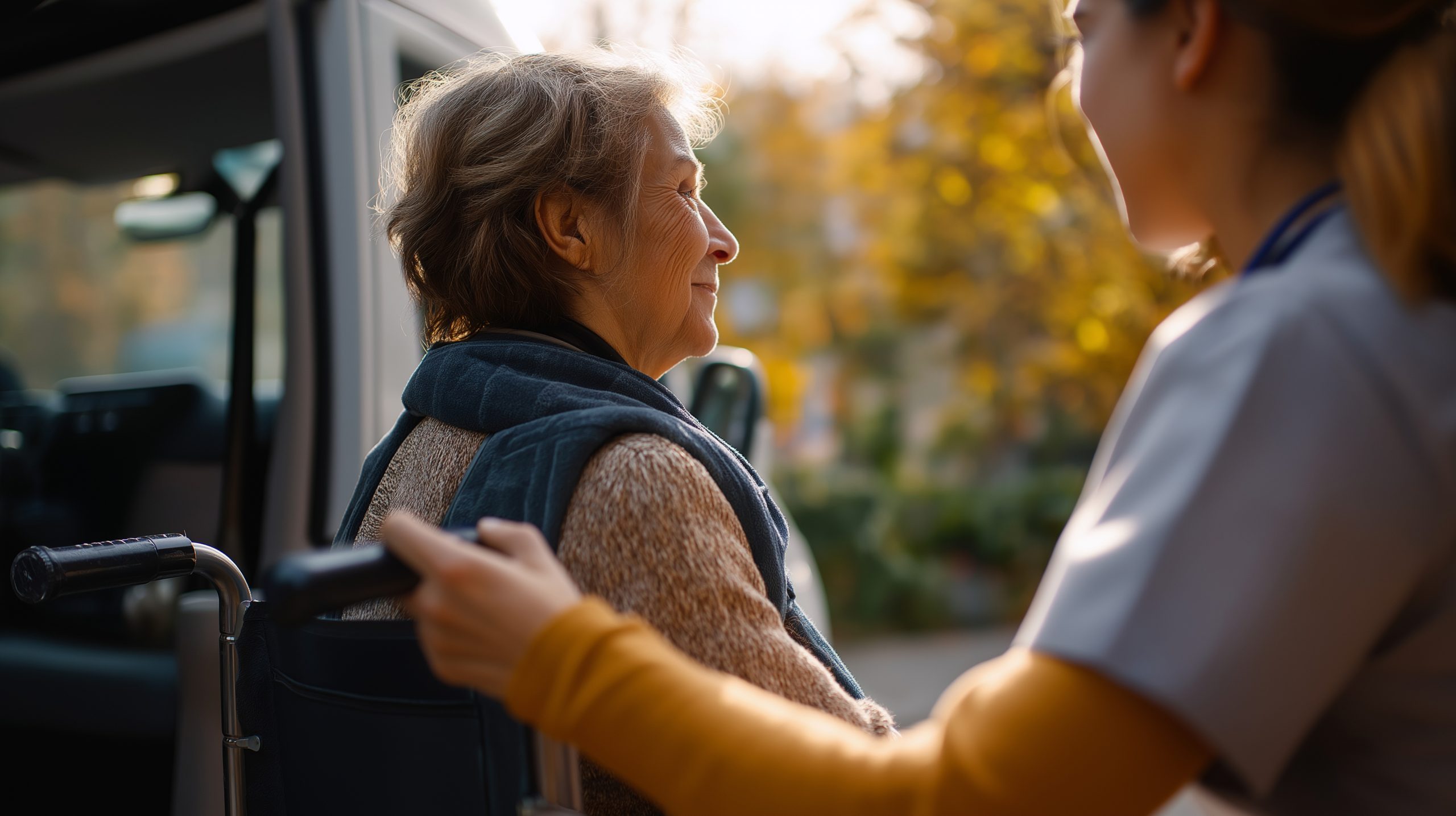 A caregiver assisting a smiling elderly woman outside