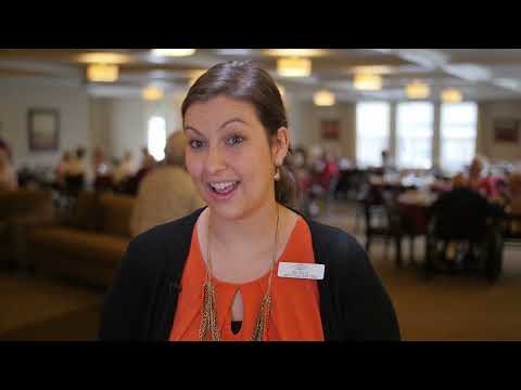 Staff member engaging with residents in the dining area
