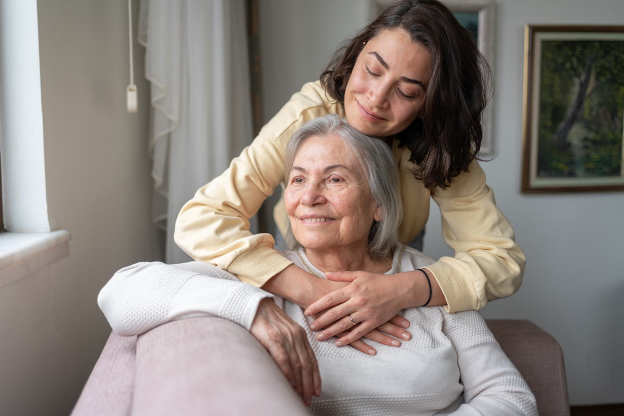 A resident enjoys time with her caregiver indoors