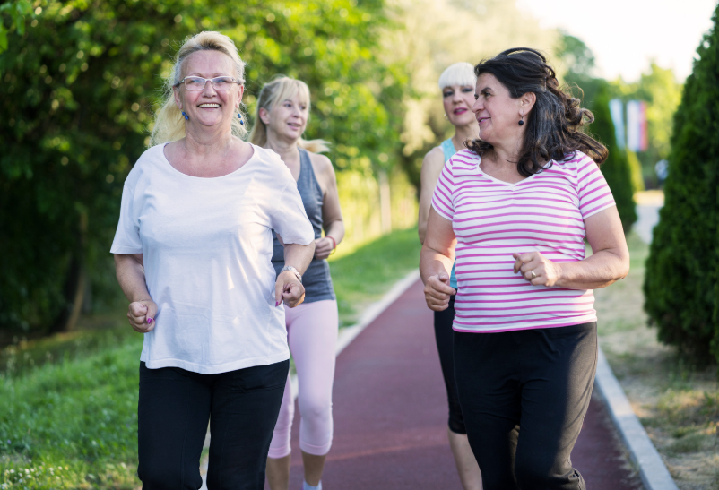 A group of women jogging on a path in a garden