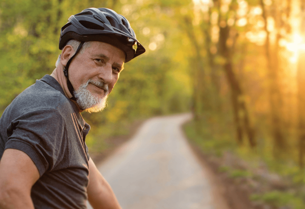 Senior man enjoying a bike ride in a forested area