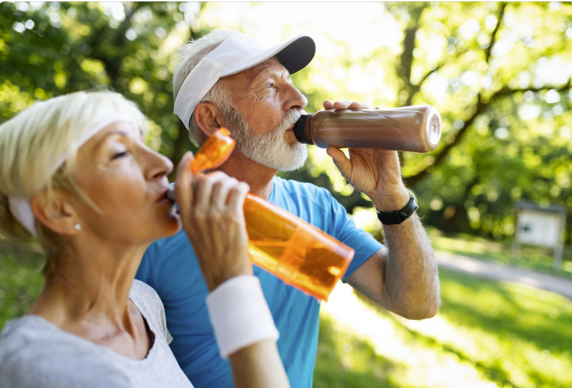 Older adults exercising outdoors with water bottles