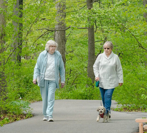 Two residents walking on a path in the woods