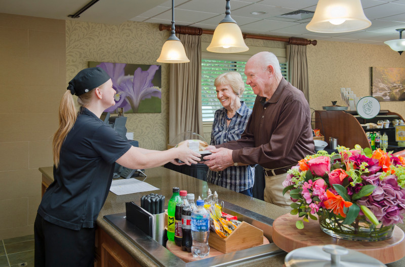 Staff serving food to residents in the dining area