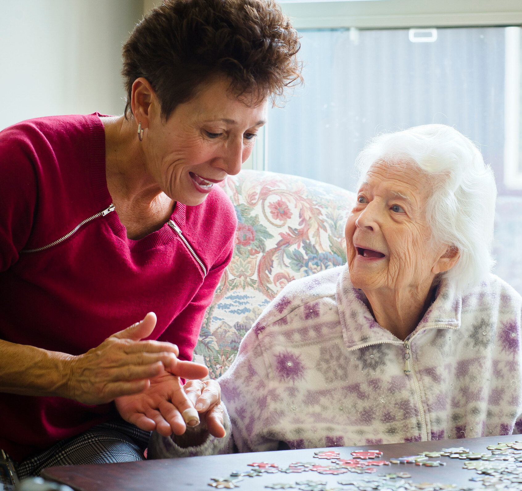Staff member engaged in a puzzle activity with a resident