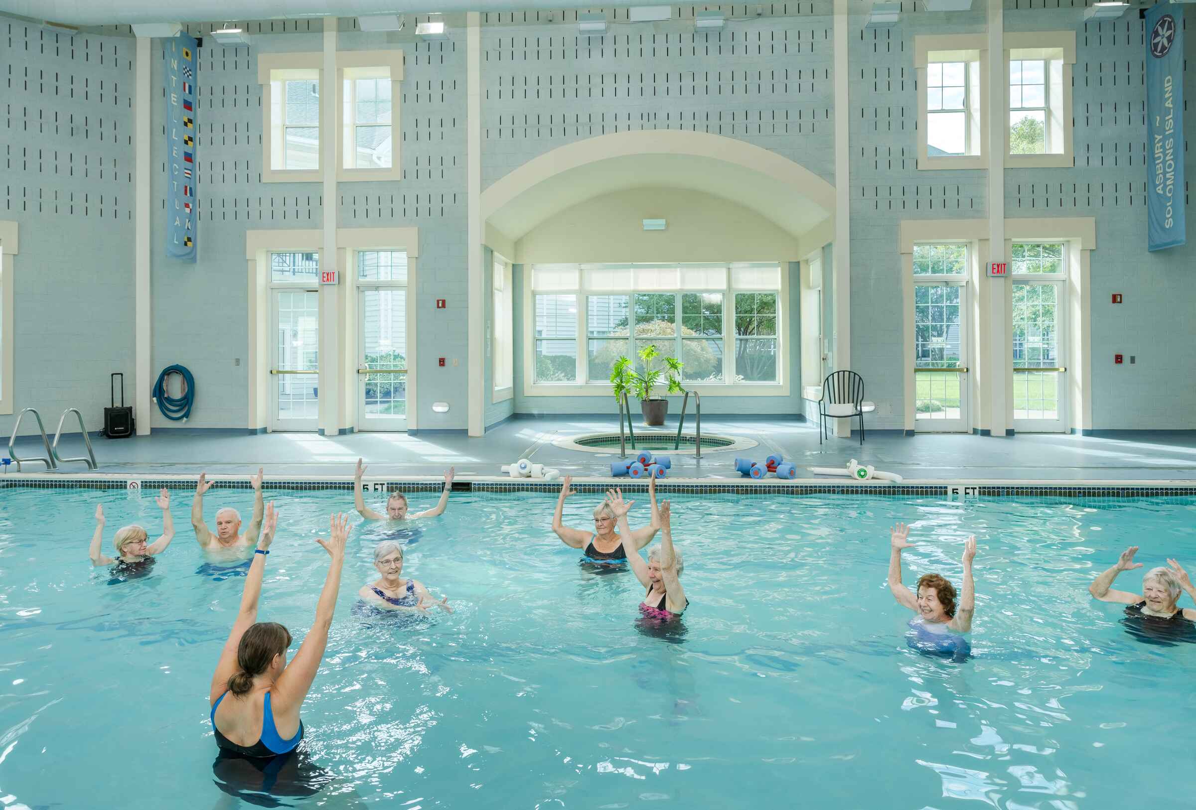 Residents participating in a water aerobics class in the pool