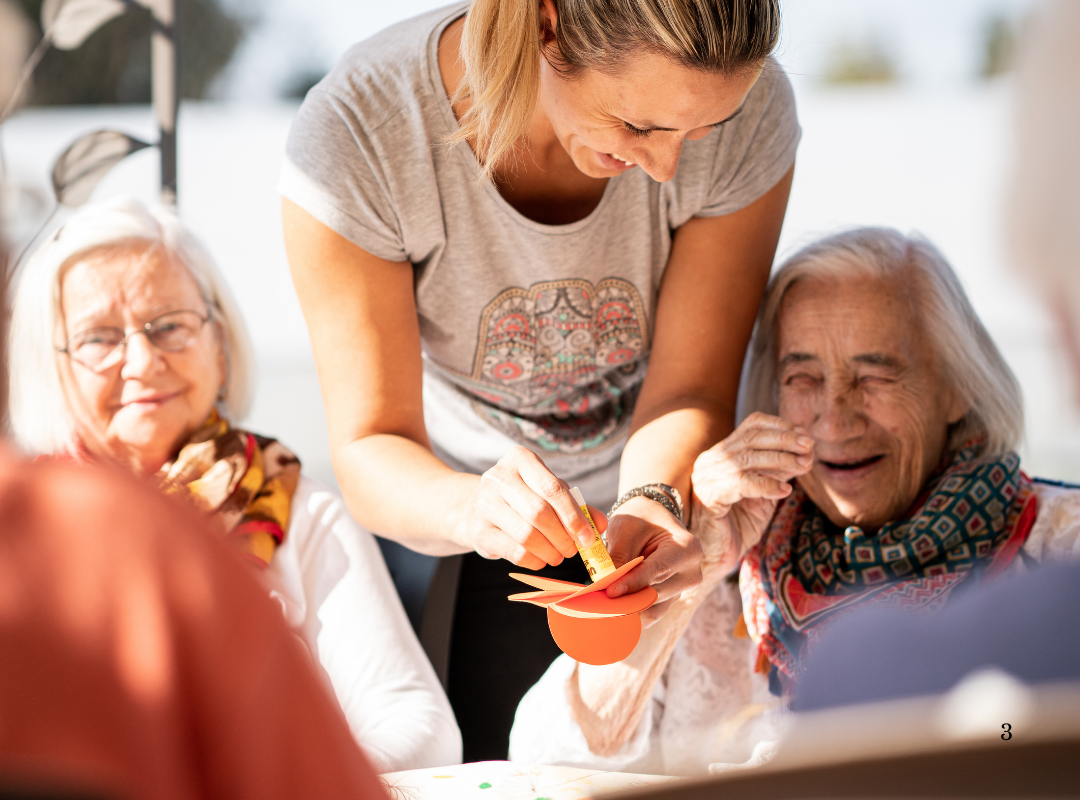 Staff assisting residents with a craft activity