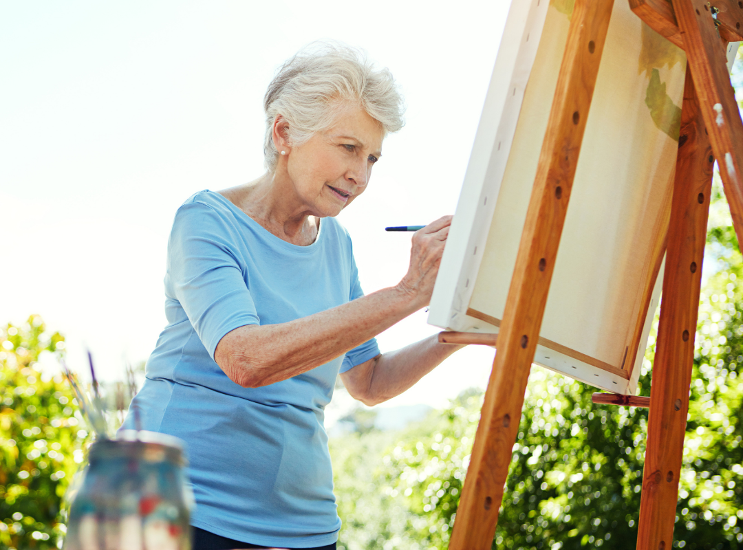 Senior woman painting in a garden setting