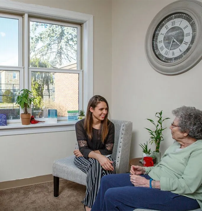 A staff member engaging with a resident in a cozy room