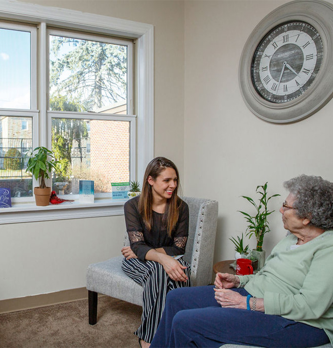 Staff member conversing with a resident in a cozy room