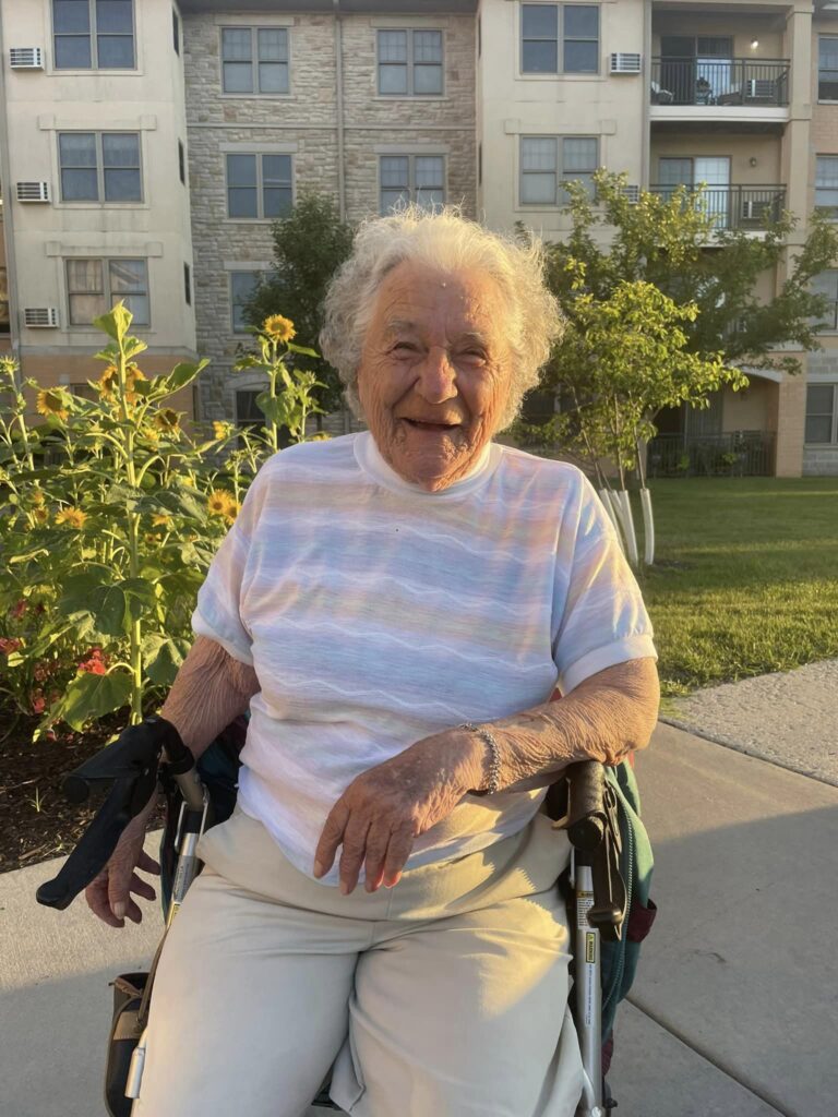 A resident smiling in a garden area
