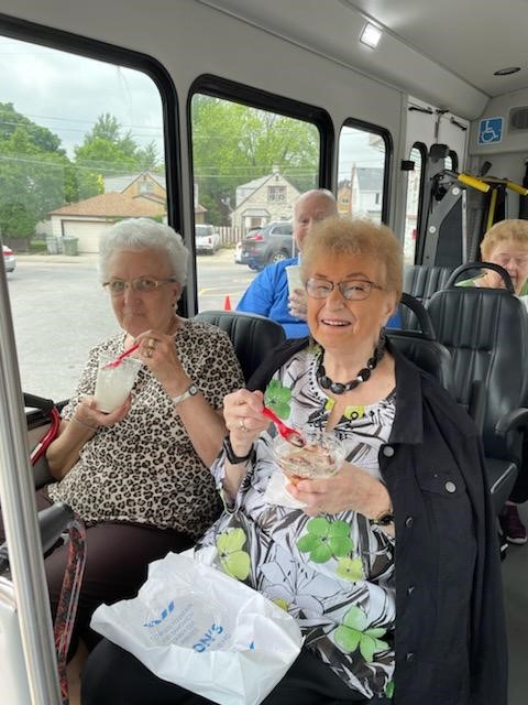 Residents enjoying ice cream on a facility transport bus