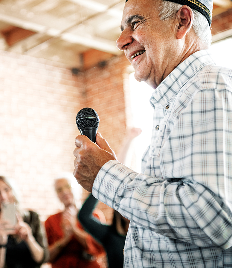 Resident speaking at a community event with audience