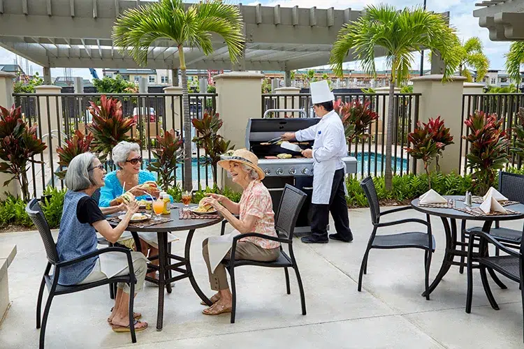 Residents enjoying lunch outdoors by the pool