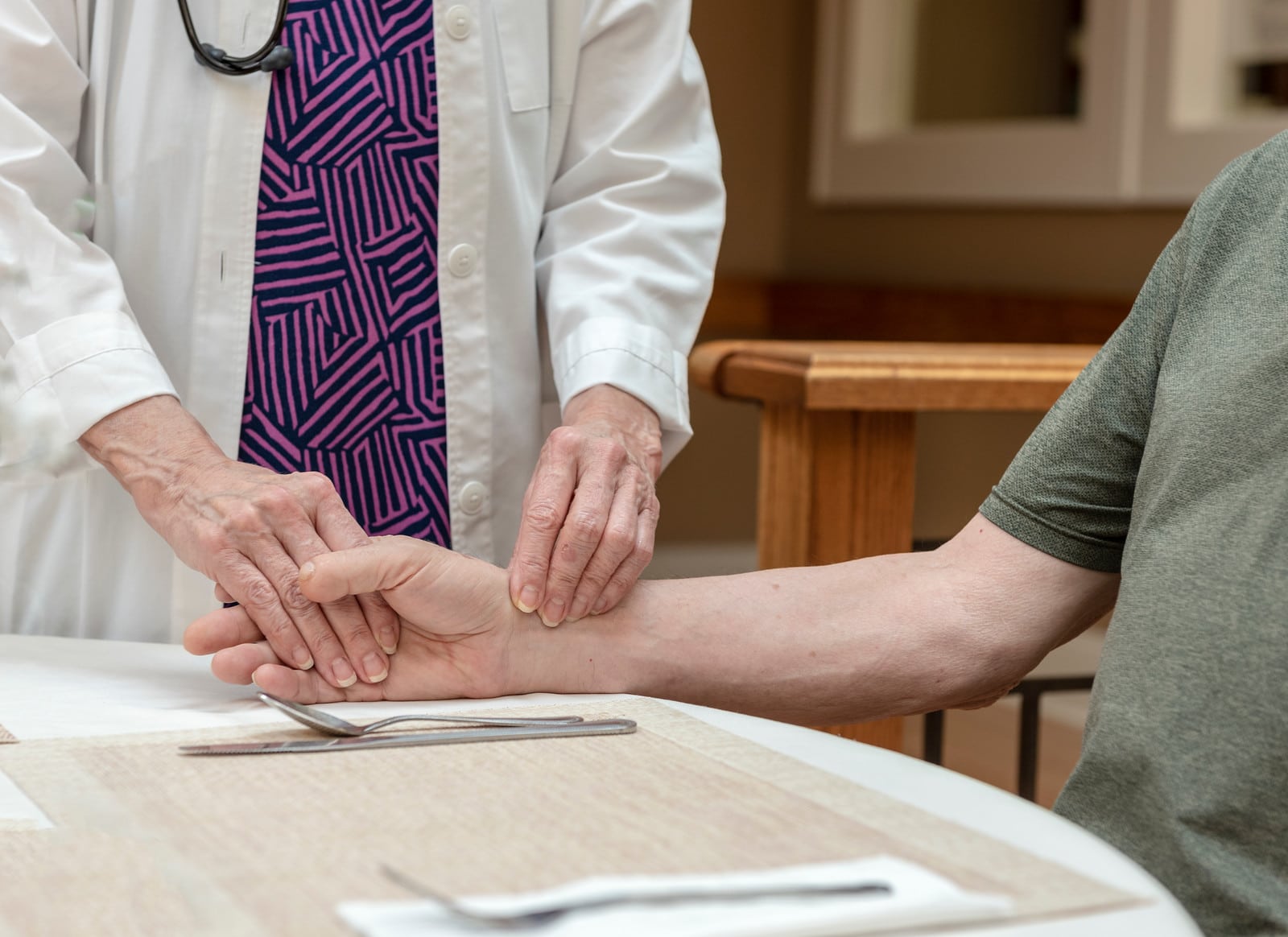 Caregiver checking resident's pulse.