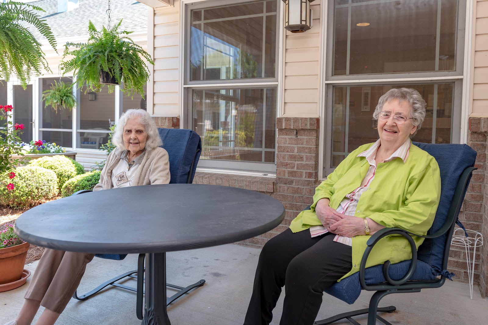 Two residents enjoying time outdoors on a patio.