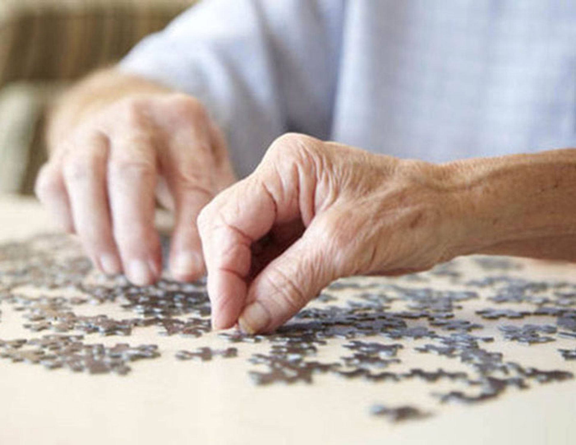 Hands working on a jigsaw puzzle