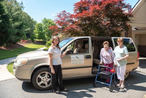 Residents boarding a facility transport van outside.