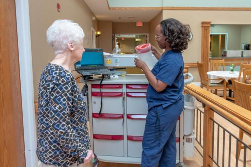 Resident and staff member interacting in a common area.