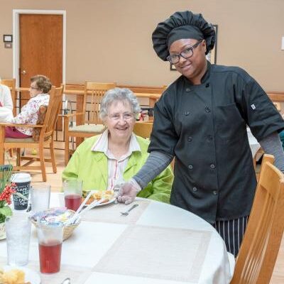 Resident enjoying a meal with a staff member.