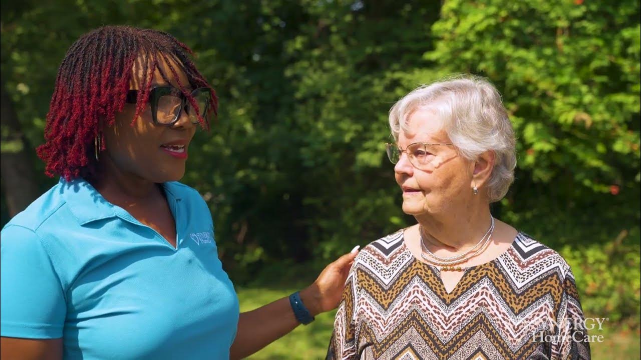 Staff member chatting with a resident outdoors.