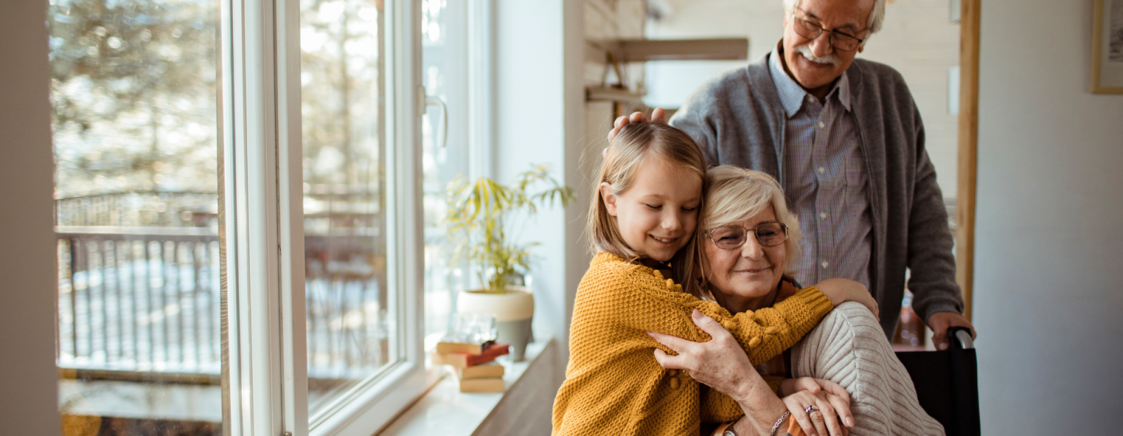 Senior woman receiving a hug from a girl and a man