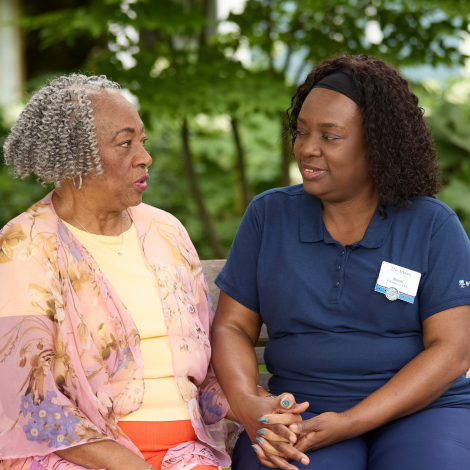 Two women engaging in conversation outdoors.