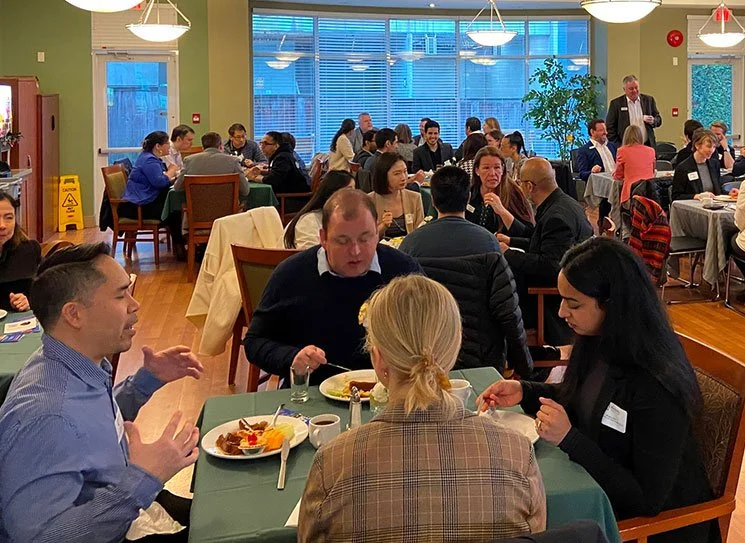 Residents and staff enjoying a meal in a dining area.