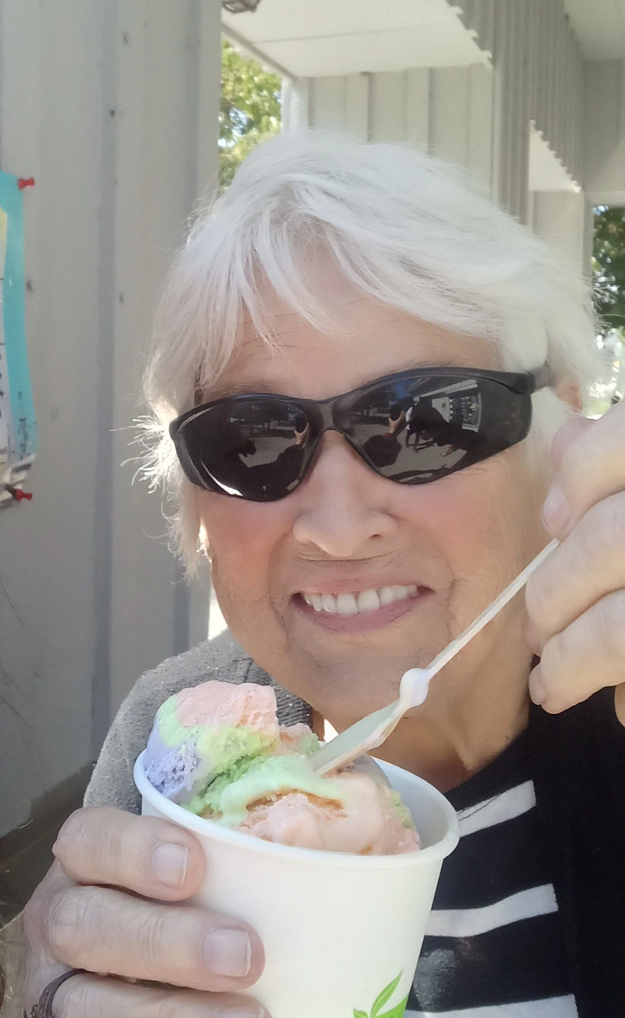 Senior woman enjoying ice cream outdoors.