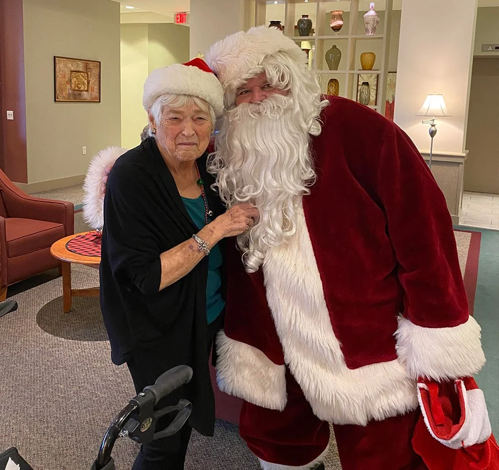 Resident and Santa celebrating in the common area