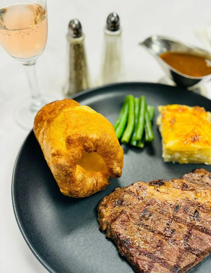Gourmet meal with steak, vegetables, and a dessert