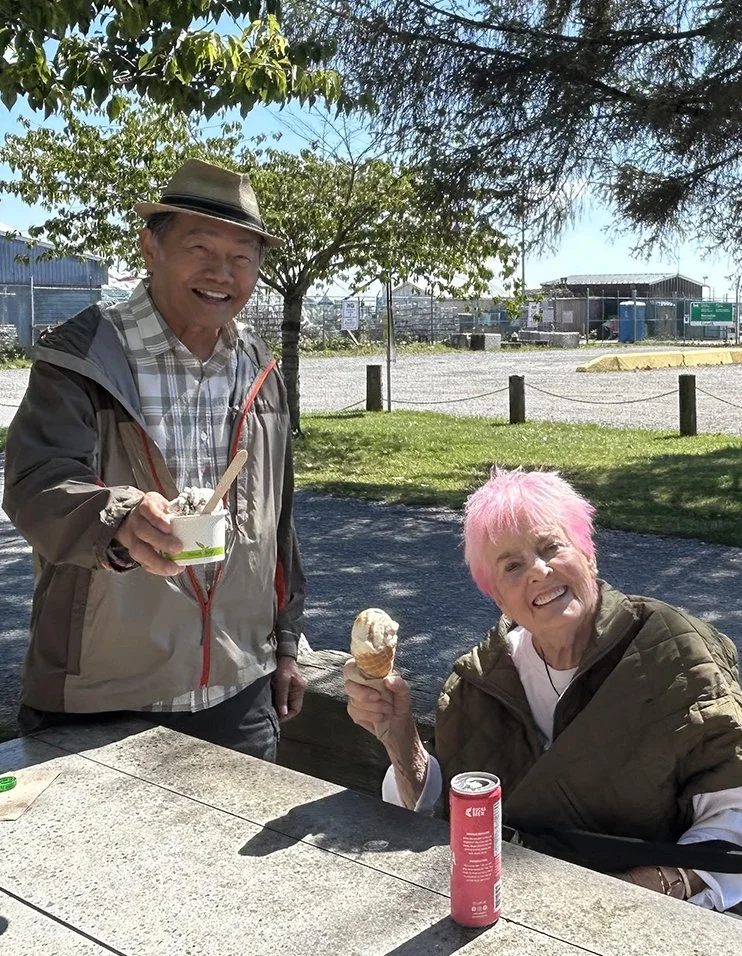 Two seniors enjoying ice cream outdoors.