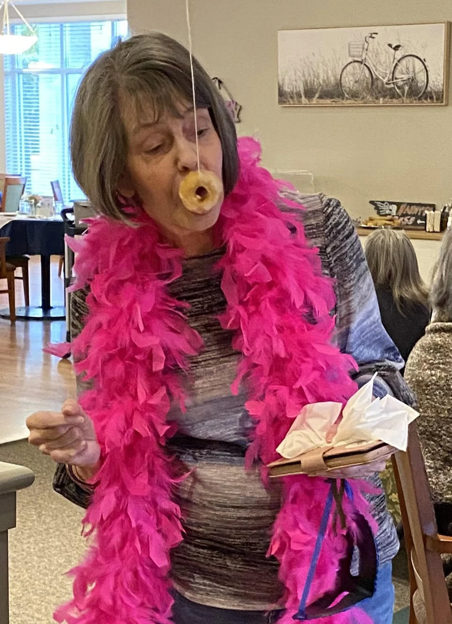 Resident participating in a fun activity with a donut.