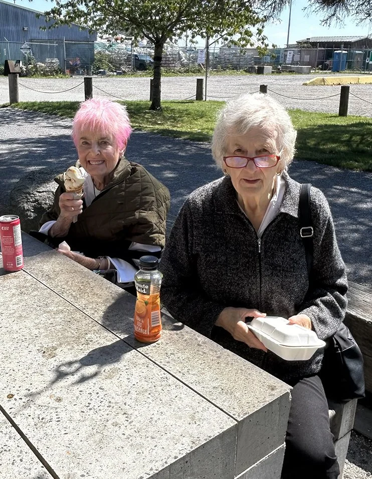 Two women enjoying ice cream outdoors