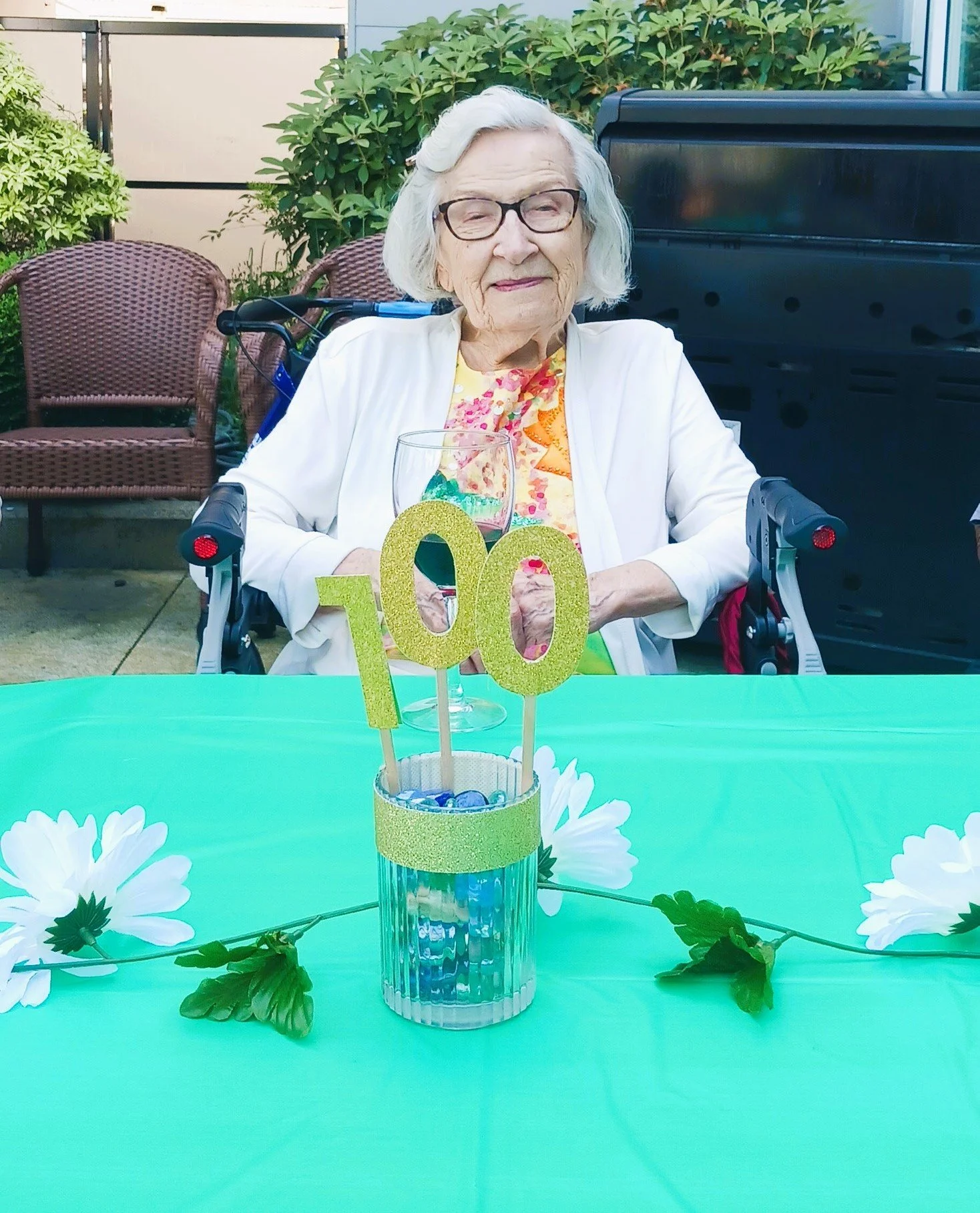 Celebration of a resident's 100th birthday outdoors.