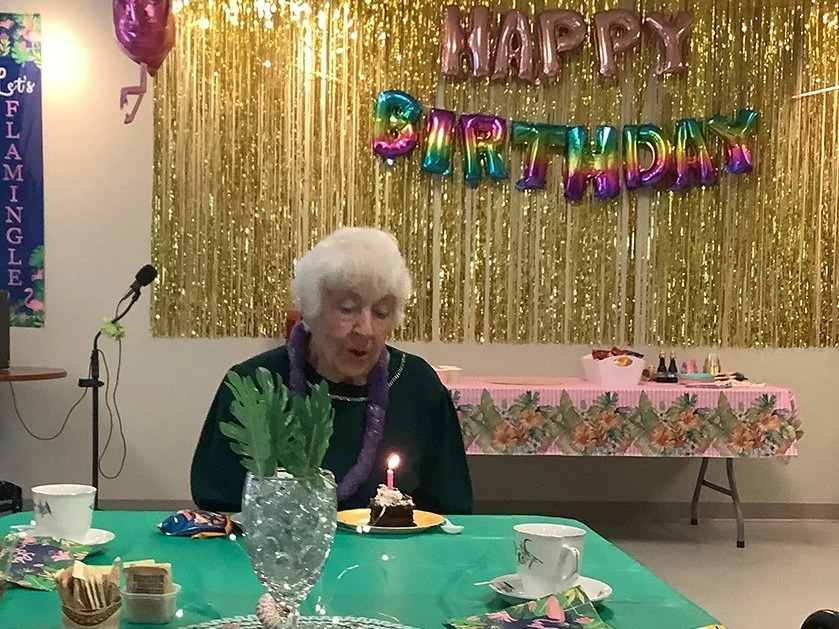 Resident celebrating a birthday with cake and decorations.