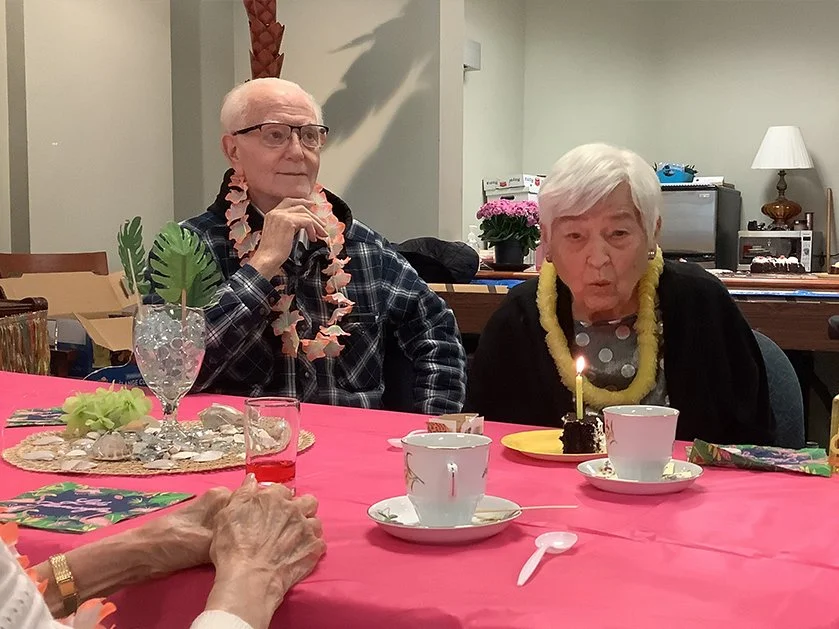 Residents celebrating a birthday with cake and decorations