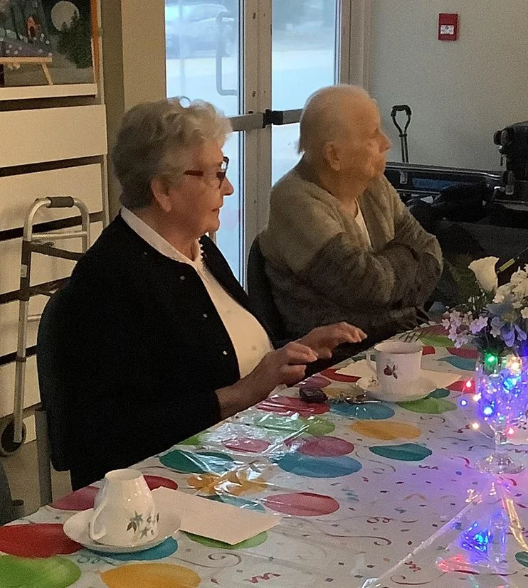Residents enjoying a celebration at a table.