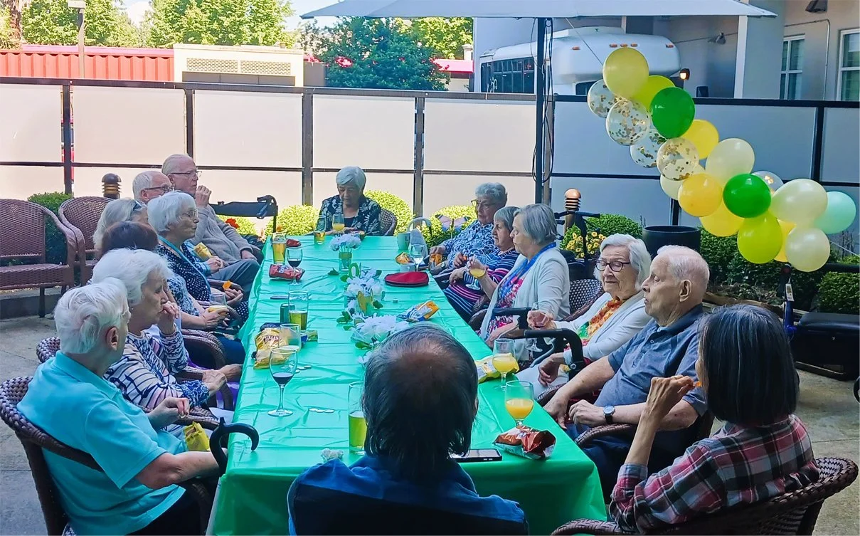 Residents enjoying outdoor gathering with colored balloons.