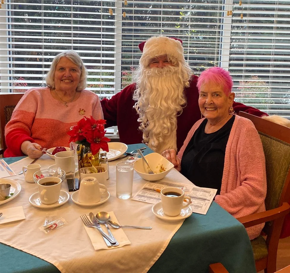 Residents enjoying a meal with Santa Claus.